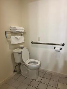 a bathroom with a toilet and towels on the wall at Super 8 by Wyndham Nebraska City in Percival +11 photos