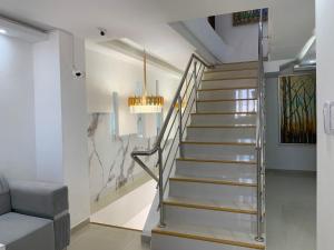 Una escalera en una sala de estar con una lámpara de araña. en Hotel Boulevard 58, en Galapa