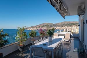 a balcony with a table and chairs and the ocean at Summer Dream Penthouse in Sarandë