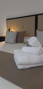 a bed with two towels sitting on top of it at Panacea Hotel in Villa General Belgrano