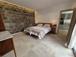 a bedroom with a bed and a stone wall at Casa Federico & Manuela – Piscina Climatizada in Mogán +31 photos