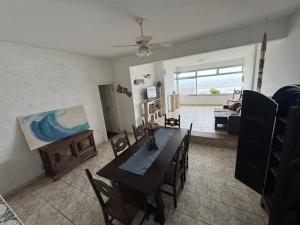 a living room with a table and a painting on the wall at Apartamento em frente ao mar in Guarujá