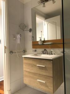 ein Badezimmer mit Waschbecken und Spiegel in der Unterkunft MZA Departamentos in Mendoza