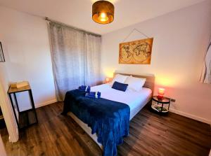 sypialnia z łóżkiem z niebieskim kocem w obiekcie Appartement Résidentiel avec parking/Proche Centre w mieście Angoulême