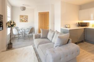 a living room with a couch and a kitchen at Stylish 1 Bed Apartment in Town Centre in Berwick-Upon-Tweed