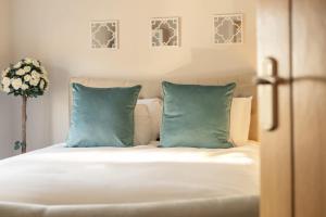 a bed with two blue pillows in a bedroom at Stylish 1 Bed Apartment in Town Centre in Berwick-Upon-Tweed