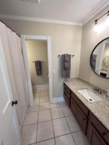 a bathroom with a sink and a mirror at Coaches House - 2 miles from Ben Griffin Stadium in Gainesville