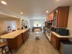 a large kitchen with wooden cabinets and a stove top oven at Coaches House - 2 miles from Ben Griffin Stadium in Gainesville