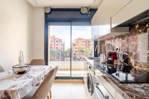 a kitchen with a table and a large window at la cocon paisible de Marrakech in Marrakech