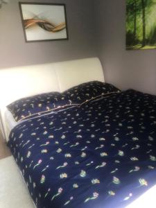 Una cama con un edredón azul en un dormitorio. en River view, en Piešťany