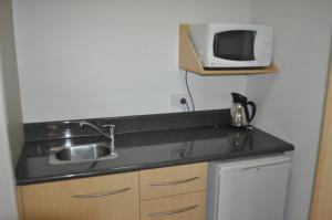a kitchen counter with a sink and a microwave at In Town Motor Inn in Taree