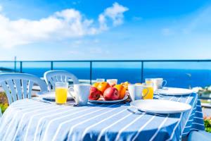 a table with a plate of fruit and glasses of orange juice at Casa Luciano in Estreito da Calheta