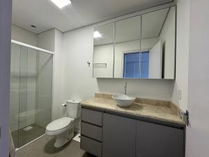 ein Badezimmer mit Toilette, Waschbecken und Spiegel in der Unterkunft Apto aconchegante e moderno in Santana do Livramento