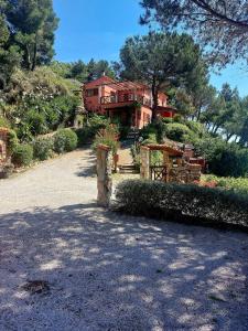 a large red house with a driveway in front of it at two-room apartment with parking space in Rio nellʼElba