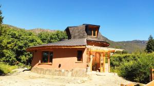 a small house with a tin roof on top at Nautilus Ecocasa Lago Puelo in Lago Puelo