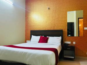 a bedroom with a large bed with a red pillow at Avini Stay in Mysore