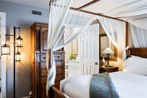 a bedroom with a canopy bed with white drapes at Hidden Creek Canyons Retreat, Alpine Charm, Private Hot Tub, Sleeps 8, Cozy Fireplace, in Park City +29 photos