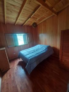 マル・デル・プラタにあるCasa de Marの木製の部屋にベッド1台が備わるベッドルーム1室があります。