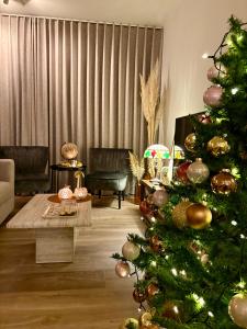 a living room with a christmas tree in a living room at Modern luxurious suite in new private apartment building by the river in Harelbeke