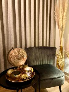 a living room with a chair and a table with a lamp at Modern luxurious suite in new private apartment building by the river in Harelbeke