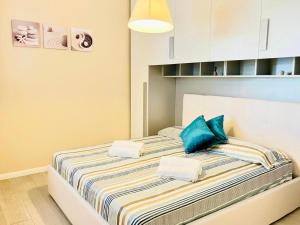 two beds in a small room with blue pillows at Villetta con piscina e ampio giardino in Stintino
