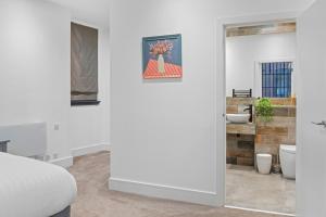 ein weißes Badezimmer mit Waschbecken und Spiegel in der Unterkunft Luxury 2-Bed Apartment with Parking & Terrace in Nottingham + 32 Fotos