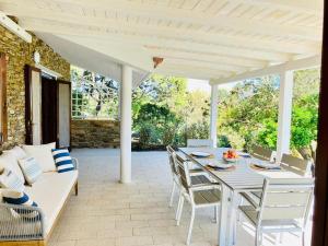a patio with a table and chairs and a couch at Villetta con piscina e ampio giardino in Stintino