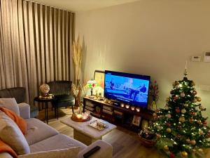 a living room with a christmas tree and a television at Modern luxurious suite in new private apartment building by the river in Harelbeke