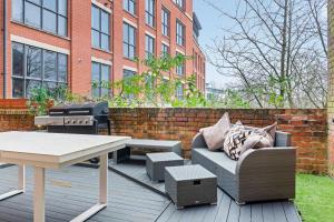 eine Terrasse mit einem Grill, einem Sofa und einem Tisch in der Unterkunft Luxury 2-Bed Apartment with Parking & Terrace in Nottingham