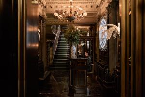 a hallway with stairs and a chandelier in a building at 100 Princes Street in Edinburgh