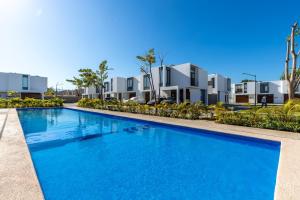 a blue swimming pool in front of some apartments at Ebano Residential in Las Juntas
