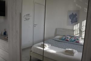 a bedroom with a mirror and a bed in a room at Casa Gimaga in Pozzuoli