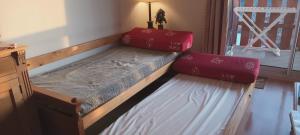 a bed with two red pillows on it in a room at Vue panoramique - Confortable - Piscine - Randonnées - Skis in Font Romeu Odeillo Via +14 photos