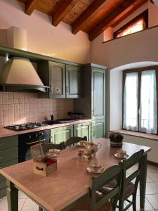a kitchen with a wooden table with chairs and a tableablish at Cascina del Pozzo in Palazzago +6 photos