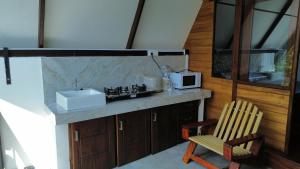 a kitchen with a sink and a chair and a microwave at Hideout Galle in Galle