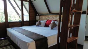 a bedroom with a bed with white sheets and red pillows at Hideout Galle in Galle