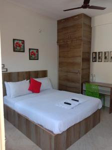 een slaapkamer met een groot wit bed met rode kussens bij Sk Residency in Bangalore