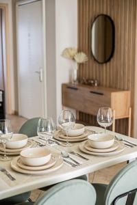 a table with plates and wine glasses on it at Ariadnes cosy apartment- walk everywhere in Alexandroupoli