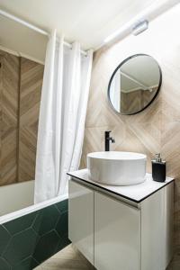 a bathroom with a white sink and a mirror at Ariadnes cosy apartment- walk everywhere in Alexandroupoli +10 photos