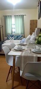 un salon avec deux lits et une table avec des assiettes dans l'établissement Coho The Hermosa - Staycation Studio Unit and Balcony View with Swimming Pool and Open Court access, à Manille