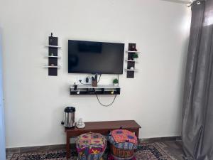 un salon avec une télévision sur un mur blanc dans l'établissement Golden Peacock Heritage Home Stay, à Jaipur