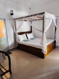 un letto con baldacchino in una stanza di Eden Villa - Ahangama ad Ahangama