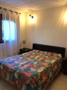a bedroom with a bed with a colorful quilt on it at Claro de luna in Villa Gesell
