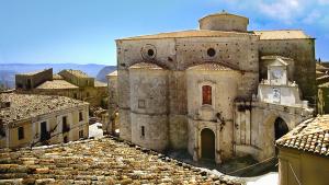an old building with a clock tower on top of roofs at Casa Vacanza Casarcobaleno in Ardore Marina
