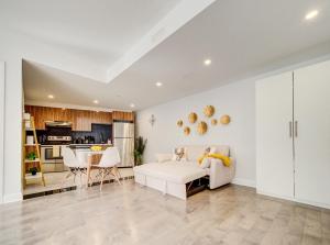 a living room with a white couch and a kitchen at Glamorous 1BR in Downtown MTL 28 in Montréal +3 photos