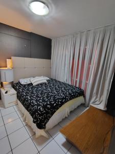 a bedroom with a black and white bed and a window at Flat 203 Ed Clarice Lispector, Ilhotas- Rio Poty in Teresina