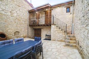 a patio with a table and chairs in a stone building at Eftychia's House in Lofou