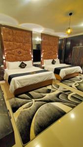 two beds in a hotel room with a carpet at Hotel Oasis in Islamabad