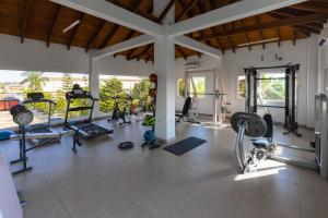 a gym with several treadmills and machines in a room at Bragha Apartments And Hotel in Takoradi