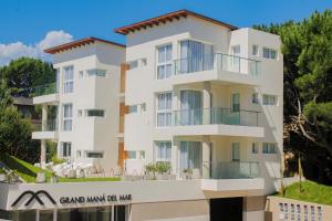 un grand bâtiment blanc avec une enseigne devant dans l'établissement Grand Maná, à Las Gaviotas
